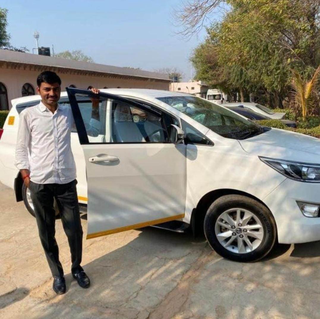 a man standing next to a car.