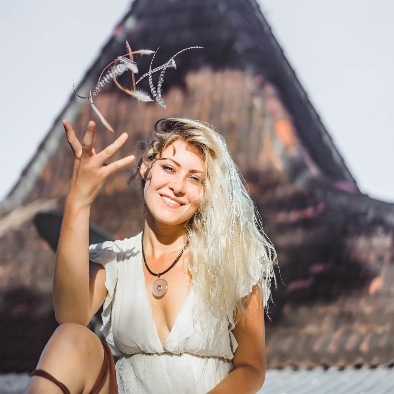 hippie girl with long blond hair in a dress on the roof.