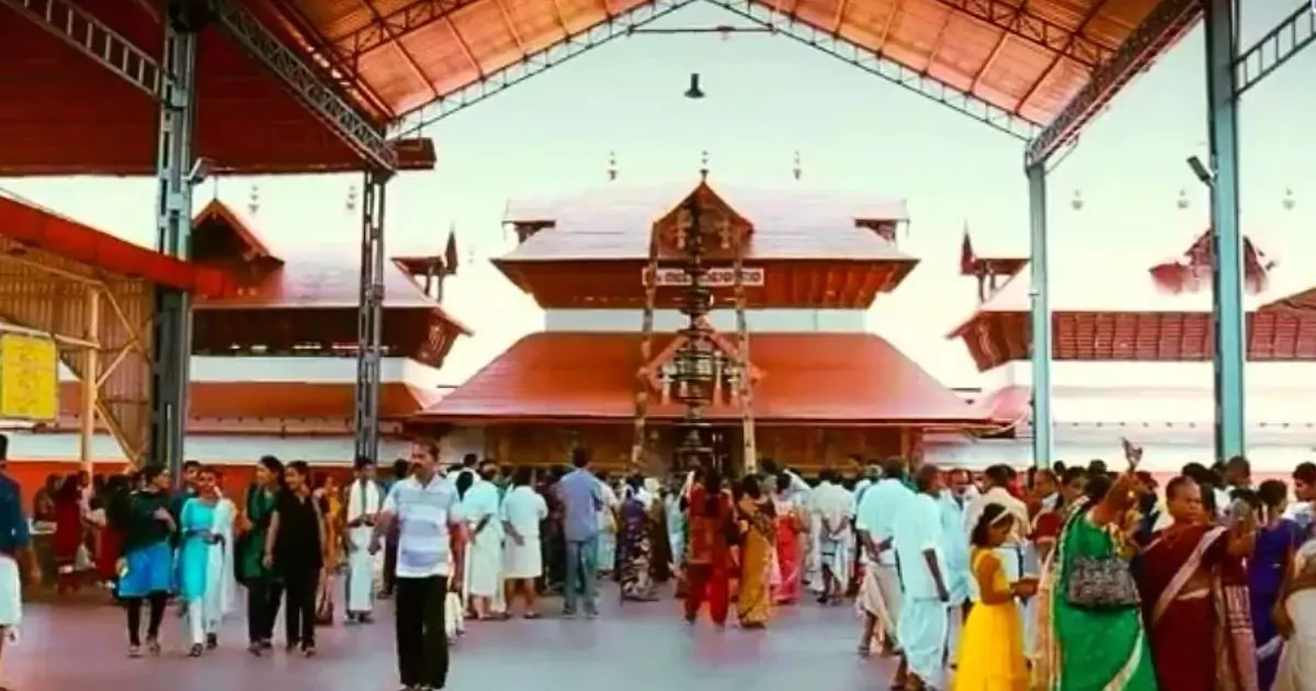 Guruvayur Temple with devotees under ornate red roof structure 